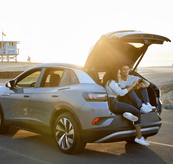 Image of a young couple sitting in the trunk of an SUV