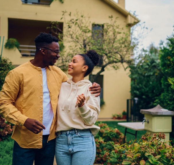 image of a young couple standing outside of their new home