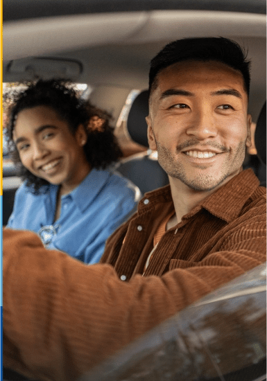 Couple smiling looking out the window of car