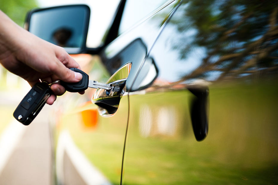 Person using a key to unlock a car door