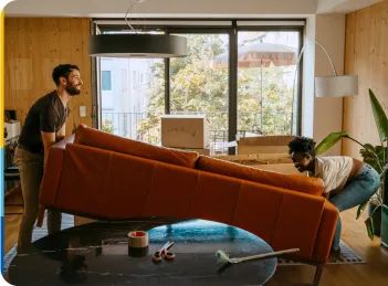 Young couple moving a couch into their new home